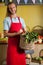 Smiling male staff holding leafy vegetables in basket at organic section