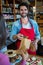 Smiling male staff putting cookies in paper bag