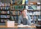 Smiling male student with open book working in a library