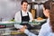 Smiling male worker serving customer with smile at shawarma place