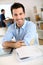 Smiling man with arms crossed sitting in office