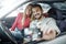 Smiling man with brackets and smiling woman inside a car making a selfie