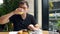 Smiling man drinking pineapple juice, eating breakfast with fresh bakery