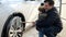 Smiling man with his baby son washing dirty car wheels at carwash. Automobile care, transport cleaning, dirty car.