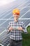 Smiling man with hundred dollar bill in hand shows thumb a sign like at the background of solar station