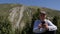 Smiling man with mobile phone surfing internet networks in mountain landscape