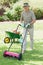 Smiling man mowing lawn