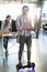 Smiling man standing on hoverboard and using laptop in office