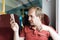 A smiling man in a suburban train making a selfie shoot by mobile phone