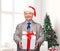 Smiling man in suit and santa helper hat with gift