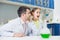 Smiling man teacher looking at excited girl student during experiment in lab