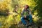 Smiling man in thought sits on a background of the quiet river