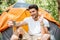 Smiling man tourist taking selfie with smartphone at touristic tent