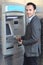 Smiling man withdrawing money at ATM