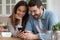 Smiling man and woman looking at smartphone screen together