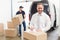 Smiling manager standing behind stack of cardboard boxes