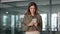 Smiling mature business woman holding smartphone standing in corporate office.