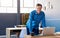 Smiling mature businessman leaning on his desk in an office