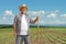 Smiling mature farmer with a shovel standing on a field