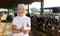 Smiling mature female proffesional farmer standing near cows