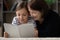 Smiling mature grandmother with little girl reading book together