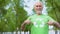 Smiling mature male pointing at recycling symbol on green t-shirt, ecology