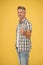 smiling mature man with grizzle hair on yellow background. thumb up