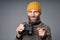 Smiling mature man in warm sweater and knitted hat holding binoculars