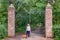 Smiling mature mexican woman with her dachshund at the park entrance