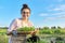 Smiling mature woman in apron with fresh spicy herbs, harvest basil