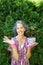 Smiling mature woman holding flower pot Bloodleaf plant