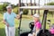 Smiling mature woman sitting in golf buggy