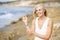 Smiling mature woman walking on the beach. Elderly female standing at a seaside location