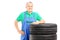 Smiling mature worker posing on car tires