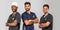 Smiling medical team standing together over light gray background. African American nurse and two Indian doctors