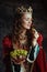 smiling medieval queen in red dress with plate of grapes