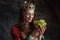 smiling medieval queen in red dress with plate of grapes