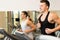 Smiling men exercising on treadmill in gym