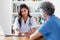 Smiling mexican female doctor listening to patient