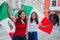 Smiling mexican women with flags enjoying Mexican Independence Day party