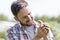 Smiling mid adult man holding small chick at farm