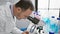 Smiling middle age man with grey hair, joyfully embracing science in his laboratory, using microscope