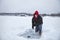 A smiling middle aged man ice fishing on a lake in Minnesota during winter