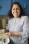 Smiling middle-aged woman cooking in kitchen