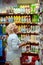 A smiling middle aged woman in a household section of a supermarket