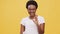 Smiling millennial african american lady gesturing ok and smiling to camera, orange studio background, slow motion