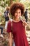 Smiling millennial African American woman hiking in a forest, waist up, close up, vertical