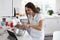 Smiling millennial woman preparing cake mixture, following a recipe on a tablet computer