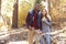 Smiling mixed race couple hike in a forest holding hands