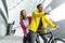 smiling mixed race man sitting on bicycle and pointing by finger to girlfriend